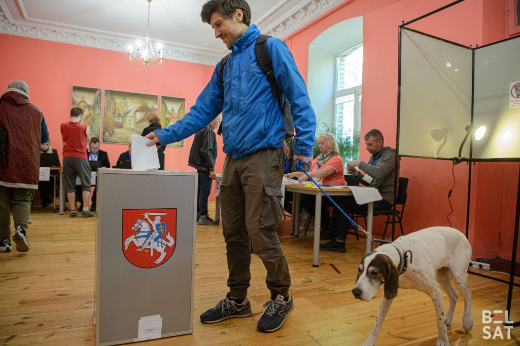 Мужчына з сабакам галасуе на выбарчым участку ў раёне Новая Вільня. Вільня, Літва. 12 тр (Фота: Белсат)