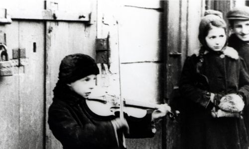 Grając np. na skrzypcach zarabiały na żywność dla siebie i rodzin. Zima 1941 w warszawskim getcie. Fot. Joe J. Heydecker/Galerie Bilderwelt/Getty Images
