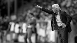 Trener Leo Beenhakker gestykuluje przy linii bocznej boiska podczas meczu, wydając wskazówki swoim zawodnikom.