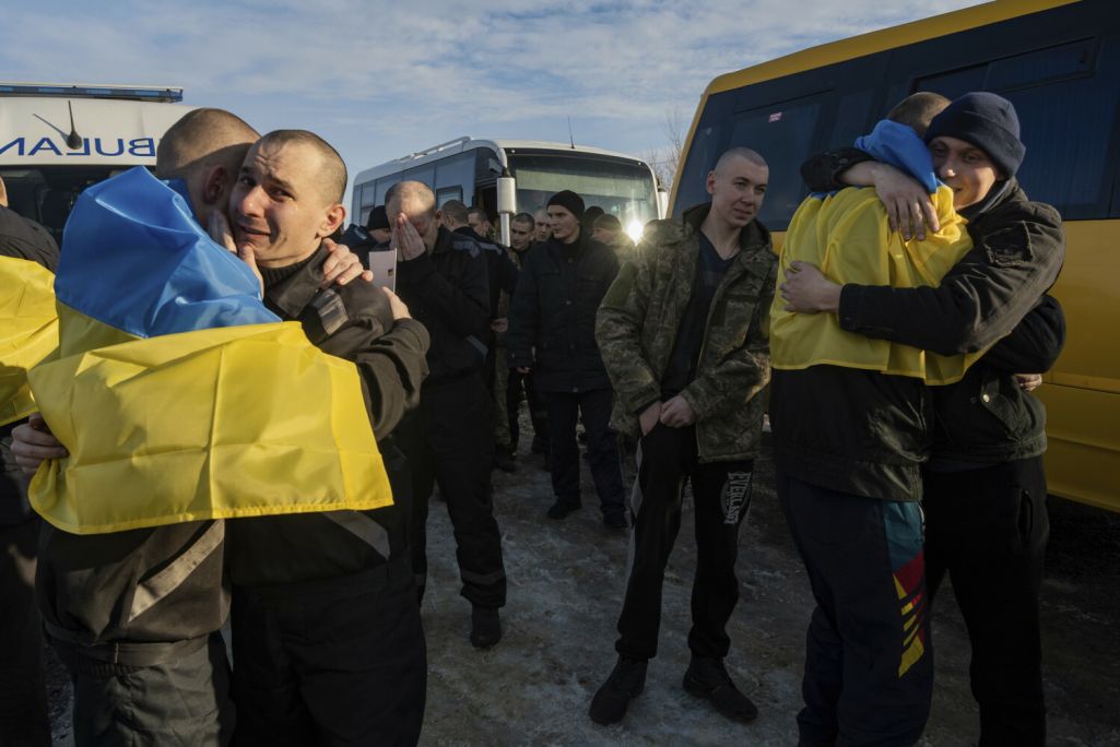 Украінскія ваеннапалонныя, стоячы ў нацыянальных сцягах, абдымаюць адзін аднаго пасля вяртання дадому на ўкраінска-расейскай мяжы. Украіна вярнула 207 салдатаў у выніку абмену палоннымі з Расеяй. Кіраўнік Офісу прэзідэнта Украіны Андрэй Ермак дадаў, што сярод вайскоўцаў шмат абаронцаў Марыупалю, вострава Змяінага і заводу«Азоўсталь». 31 студзеня 2024 года. (Фота: Danylo Pavlov / AP Photo / East News)