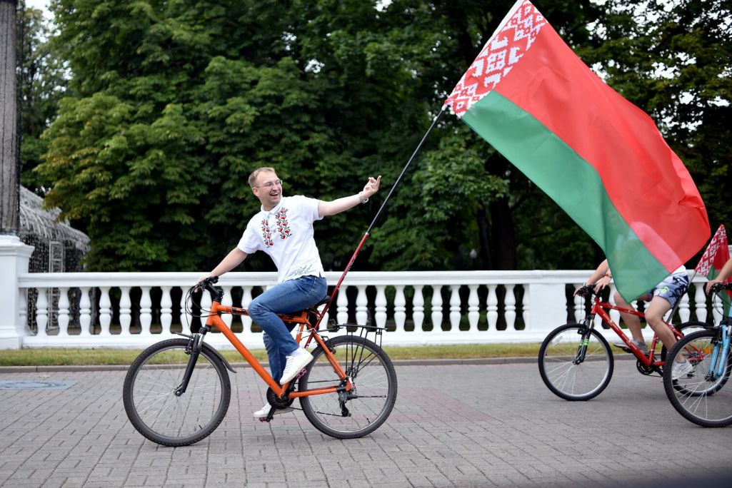 Здымак мае ілюстрацыйны характар. Дэпутат Сяргей Клішэвіч паказвае сярэдні палец у бок аўтамабілістаў падчас язды на ровары з дзяржаўным сцягам Беларусі ў Менску, Беларусь. 20 жніўня 2020 года. (Фота: Sergei Gapon / AFP / East News)