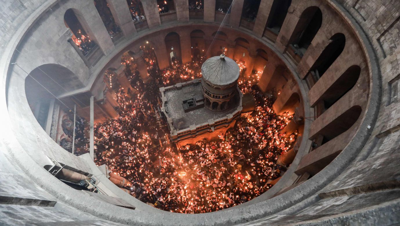 Prawosławni oczekujący na cud ognia zgromadzeni w Bazylice Zmartwychwstania wokół Grobu Pańskiego w kwietniu 2022 roku. Fot. ABIR SULTAN/EPA/PAP 