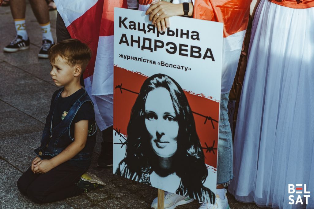 Хлопчык сядзіць каля партрэту Кацярыны Андрэевай падчас маршу прысвечанаму 4 гадавіне выбараў і пратэстаў 2020 году. Варшава, Польшча. 9 жніўня 2024 года. Фота: Белсат
