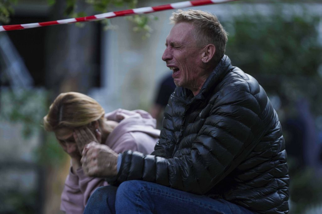 Бацька плача, пакуль ягоны сын застаецца пад руінамі пад'езду шматпавярховага жылога дому, разбуранага расейскім ударам у Кіеве. Фота: Evgeniy Maloletka / AP Photo / East News
