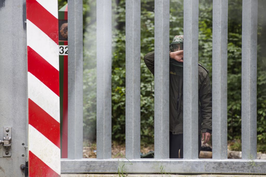 Ілюстрацыйны здымак. Мужчына глядзіць праз плот з беларускага боку беларуска-польскай мяжы. Буферная зона ўздоўж мяжы з Беларуссю, Белавежская пушча, Польшча. 6 сакавіка 2024 г. (Фота: Attila Husejnow / Forum)