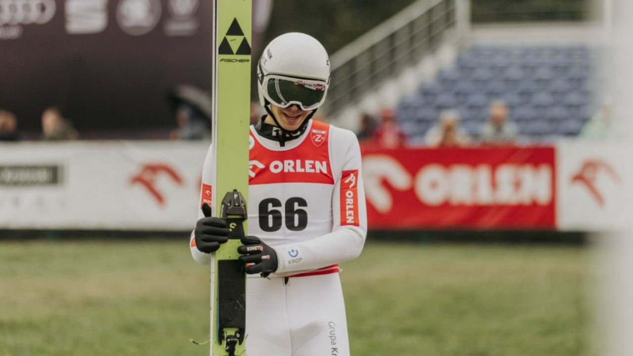 Kacper Tomasiak polski skoczek z plastronem nr 66 w trakcie zawodów PZN, ma na białym kombinezonie napis sponsorski ORLEN (fot. PZN)