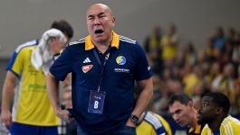 Trener Industrii Kielce, Tałant Dujszebajew, w emocjonalnym geście podczas meczu Ligi Mistrzów piłkarzy ręcznych przeciwko HBC Nantes. Szkoleniowiec wyraża frustrację po słabej drugiej połowie spotkania, które jego drużyna przegrała 27:35. W tle zawodnicy kielczan na ławce rezerwowych i rozczarowani kibice na trybunach (fot. PAP).