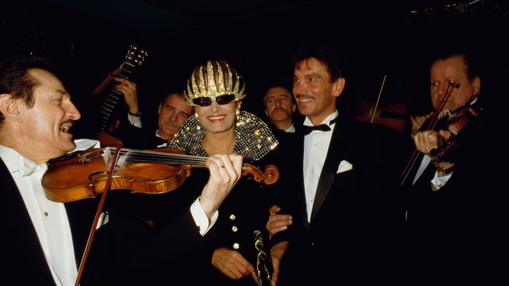 Dalida w otoczeniu muzyków na paryskiej premierze w diademowej masce kryjącej oczy po operacji. Fot. THIERRY ORBAN/Sygma/Getty Images