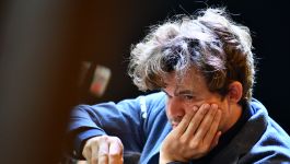 Magnus Carlsen podczas gry w szachy (fot. Getty Images) Na zdjęciu Magnus Carlsen — lider światowego rankingu FIDE — w pełnym skupieniu wykonuje ruch na szachownicy. Ubrany w granatową koszulę, z potarganymi włosami i intensywnym spojrzeniem, oddaje atmosferę napięcia typową dla turniejów najwyższej rangi. W tle widać profesjonalne zaplecze transmisyjne, co podkreśla rangę rozgrywek. Ujęcie doskonale ilustruje determinację zawodnika, który mimo upływu lat wciąż utrzymuje się na szczycie światowej elity (fot. Getty Images)