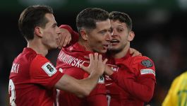 Radość reprezentantów Polski po golu strzelonym w Kownie (fot. PAP). Piłkarze reprezentacji Polski cieszą się po zdobytej bramce podczas meczu eliminacyjnego. Zawodnicy w czerwonych koszulkach obejmują się i świętują gola na tle rywala w żółtym stroju (fot. PAP).
