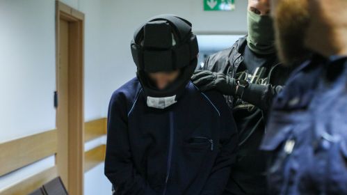 Паліцыянты вядуць Мешка Р., затрыманага за напад з сякерай на Варшаўскі ўніверсітэт, у акруговым судзе. Варшава, Польшча