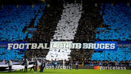 Kibice Club Brugge, który w poprzednim sezonie zdobył wicemistrzostwo Belgii (fot. Getty) Kibice na stadionie w Brugii tworzą kolorową oprawę z niebieskich, czarnych i białych kartonów oraz transparentem z napisem „Football Club Bruges” podczas meczu Ligi Mistrzów. Na murawie widać pracowników technicznych trzymających flagę UEFA (fot. Getty)