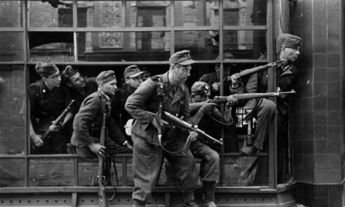 Żołnierze „Dirlewangera” w rejonie ul. Focha w sierpniu 1944. 36 Dywizja Grenadierów SS „Dirlewanger” była jednostką Waffen-SS złożoną z kryminalistów rekrutowanych w niemieckich więzieniach, dowodzoną przez Oskara Dirlewangera. Dokonała niezliczonych, wyjątkowo okutnych zbrodni na tyłach frontu wschodniego, zabijając od 60 tysięcy do 120 tys. ludzi, głównie cywilów. Fot. Bundesarchiv, Bild 183-R97906 / Schremmer / CC-BY-SA 3.0, CC BY-SA 3.0 de, https://commons.wikimedia.org/w/index.php?curid=5359723