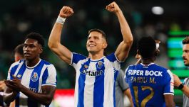 Piłkarz FC Porto Jan Bednarek unosi obie ręce w geście triumfu i uśmiecha się, świętując na boisku. Obok niego, po lewej stronie, inny zawodnik w tej samej koszulce klaszcze, patrząc na niego. Tło stanowi zielona murawa boiska, sugerująca atmosferę meczu (fot. Getty Images)