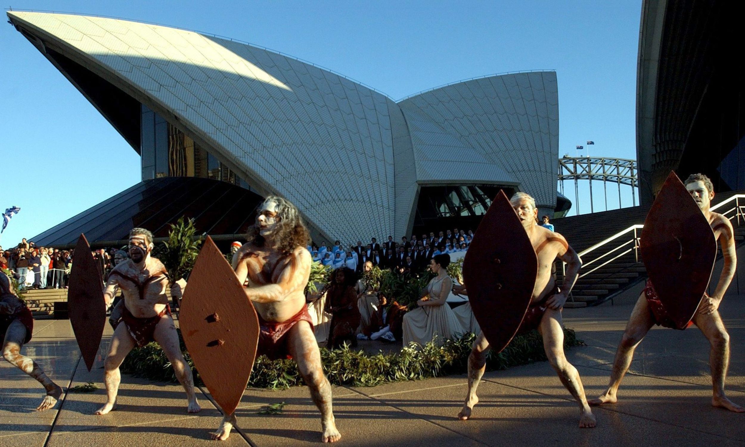  Taniec Aborygenów na powitanie sztafety z olimpijskim ogniem w pobliżu gmachu opery w Sydney w 2004 roku. Fot. PAP/EPA-PAUL MILLER