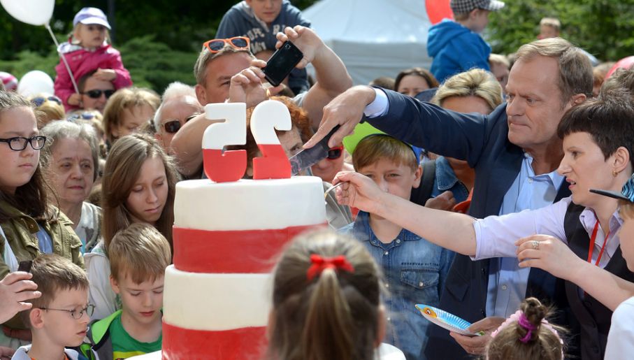 Premier Donald Tusk kroi tort podczas pikniku z okazji Dnia Dziecka (fot. PAP/Radek Pietruszka)